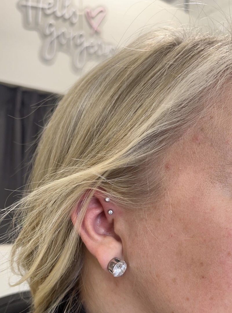 A woman with blonde hair and ear piercings.