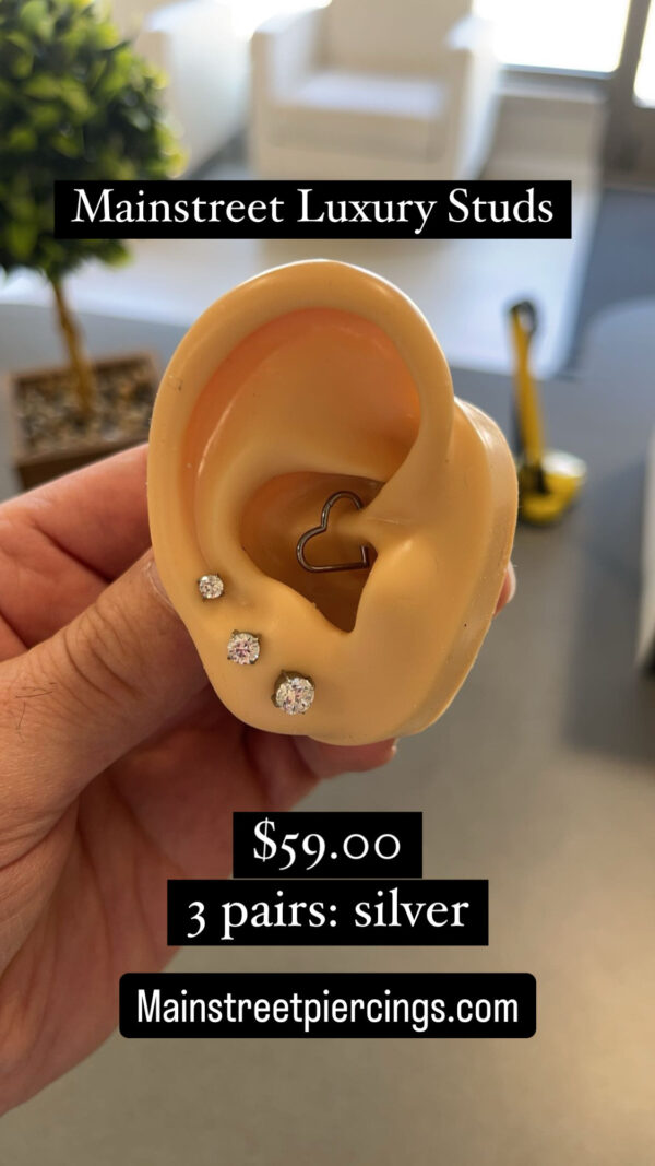 A person holding up an ear with some kind of earring