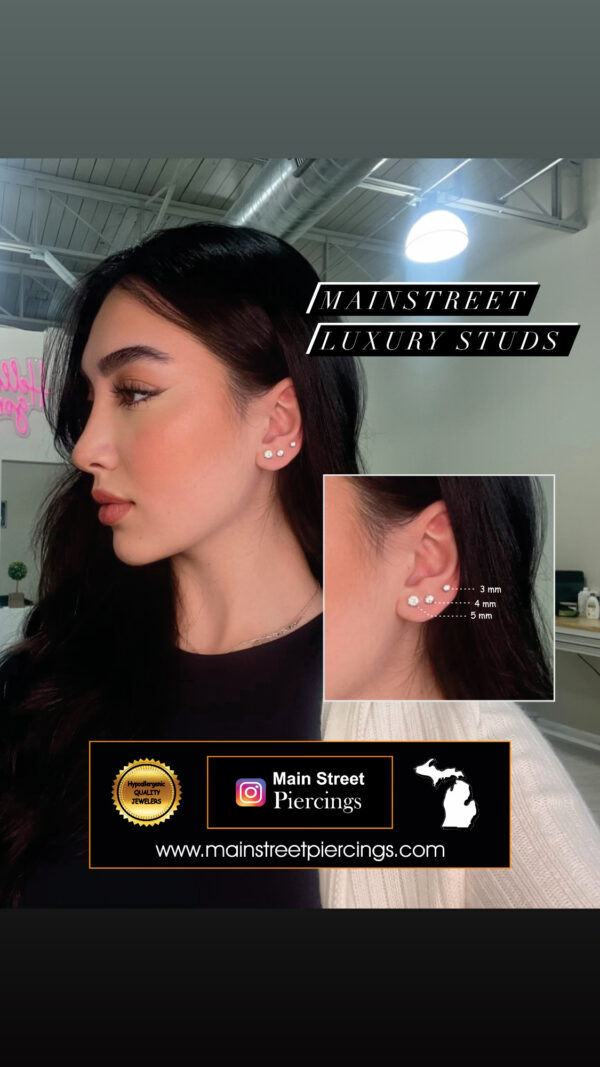 A woman wearing a pair of earrings with the words " mainstreet luxury studs ".