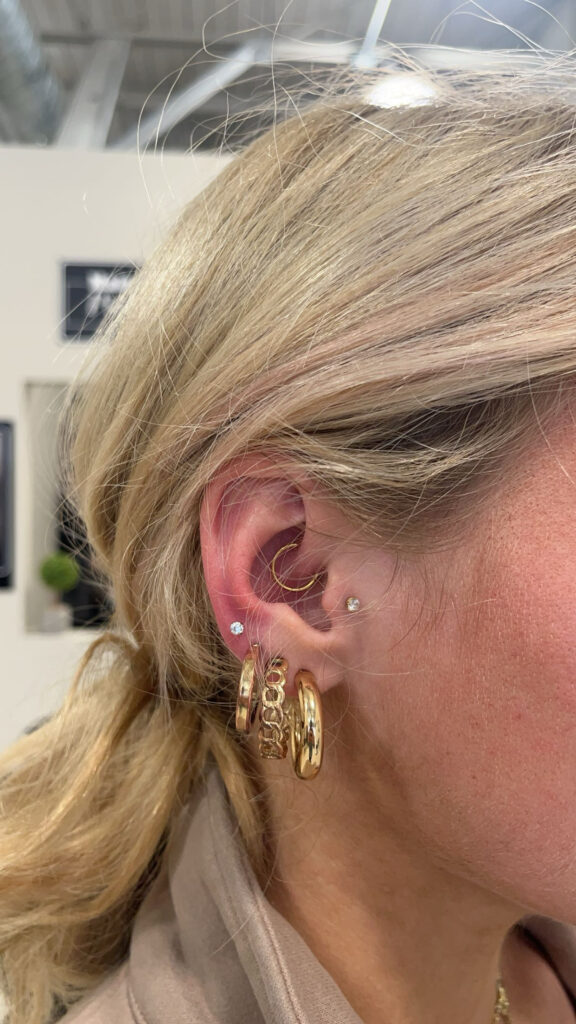 A woman with multiple piercings on her ear.