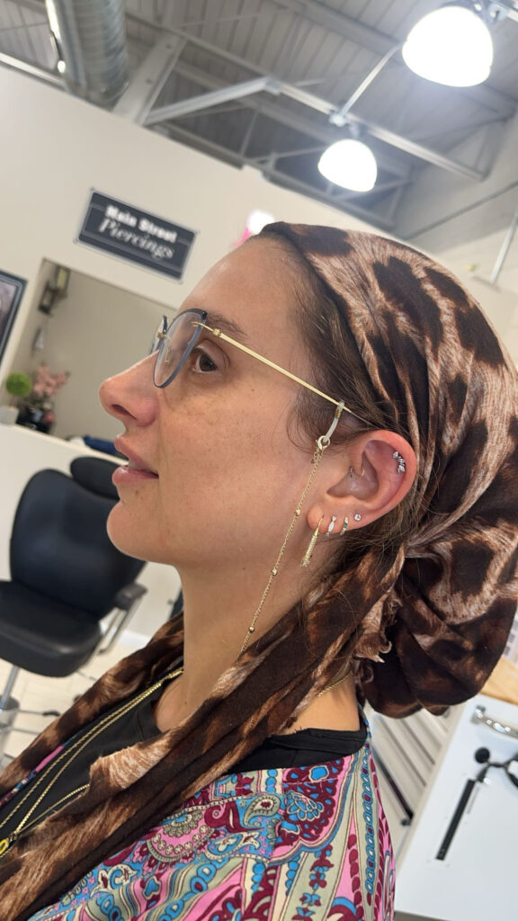 A woman with glasses and a brown scarf on her head.