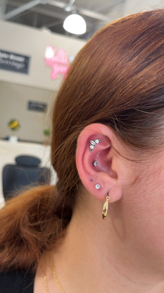 A woman with multiple piercings on her ear.