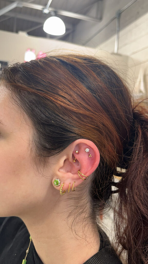 A woman with multiple piercings on her ear.